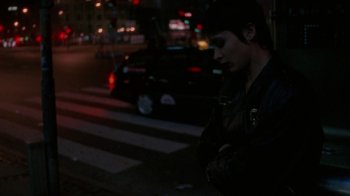 Movie still from “Pusher” (1996), directed by Nicolas Winding Refn – A person standing on the side of a road at night; Medium shot, High angle