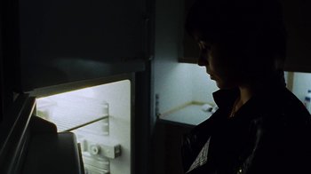 Movie still from “Pusher” (1996), directed by Nicolas Winding Refn – A woman standing in front of an open refrigerator; Close Up shot, Low angle