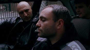 Movie still from “Pusher” (1996), directed by Nicolas Winding Refn – Two men sitting in the back seat of a car; Close Up shot, High angle
