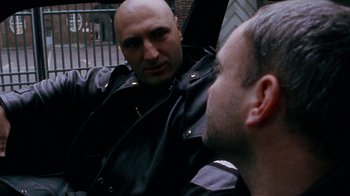 Movie still from “Pusher” (1996), directed by Nicolas Winding Refn – A man in a leather jacket looking at another man in a leather jacket; Close Up shot, Over the shoulder angle
