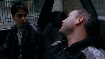 Movie still from “Pusher” (1996), directed by Nicolas Winding Refn – A man and a woman sitting in a car; Close Up shot, Over the shoulder angle