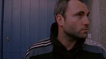 Movie still from “Pusher” (1996), directed by Nicolas Winding Refn – A person wearing a jacket; Close Up shot, Low angle