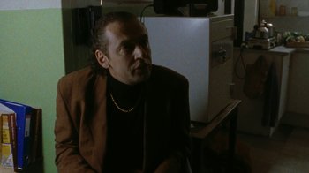 Movie still from “Pusher” (1996), directed by Nicolas Winding Refn – A man sitting in front of an open refrigerator; Close Up shot, Over the shoulder angle