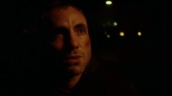 Movie still from “Pusher” (1996), directed by Nicolas Winding Refn – A person in a dark room; Close Up shot, Low angle