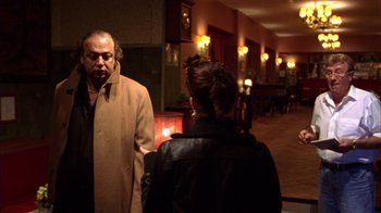 Movie still from “Pusher III” (2005), directed by Nicolas Winding Refn – A man and a woman are standing in a room; Medium shot, Over the shoulder angle