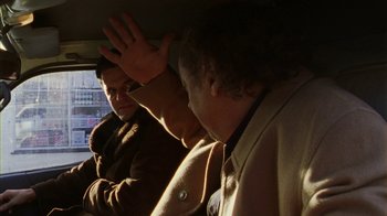 Movie still from “Pusher III” (2005), directed by Nicolas Winding Refn – Two men in the back seat of a car; Medium shot, Over the shoulder angle