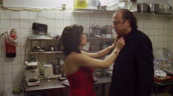 Movie still from “Pusher III” (2005), directed by Nicolas Winding Refn – A man and a woman in a kitchen setting; Medium shot, Low angle