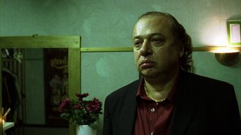 Movie still from “Pusher III” (2005), directed by Nicolas Winding Refn – A man in a red shirt and a black jacket; Close Up shot, Low angle