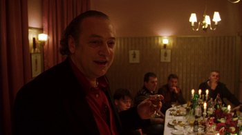 Movie still from “Pusher III” (2005), directed by Nicolas Winding Refn – A group of people sitting at a table eating food; Medium shot, Low angle