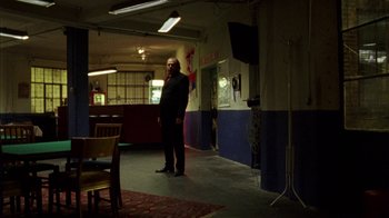 Movie still from “Pusher III” (2005), directed by Nicolas Winding Refn – A man standing in the middle of an empty room; Wide shot, Low angle