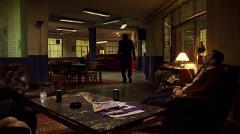 Movie still from “Pusher III” (2005), directed by Nicolas Winding Refn – A man walking through a room with a coffee table; Wide shot, Low angle