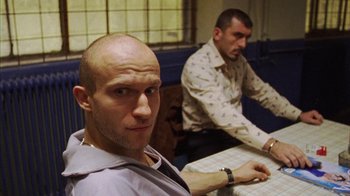 Movie still from “Pusher III” (2005), directed by Nicolas Winding Refn – Two men sitting in front of a computer screen; Medium shot, Low angle