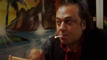 Movie still from “Pusher III” (2005), directed by Nicolas Winding Refn – A person smoking a cigarette; Close Up shot, Low angle