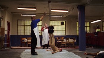Movie still from “Pusher III” (2005), directed by Nicolas Winding Refn – A man standing over a woman on a floor; Wide shot, High angle