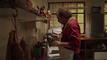 Movie still from “Pusher III” (2005), directed by Nicolas Winding Refn – A man in an apron standing in front of a counter; Medium shot, Low angle