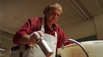 Movie still from “Pusher III” (2005), directed by Nicolas Winding Refn – A man in an apron is holding a spray bottle; Close Up shot, Low angle