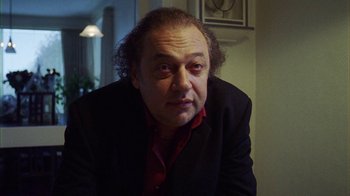 Movie still from “Pusher III” (2005), directed by Nicolas Winding Refn – A person wearing a suit and tie; Close Up shot, Low angle