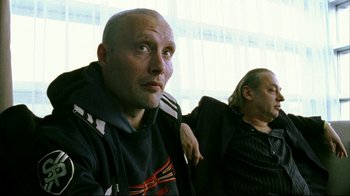 Movie still from “Pusher II” (2004), directed by Nicolas Winding Refn – Two men sitting next to each other in front of a window; Close Up shot, Low angle