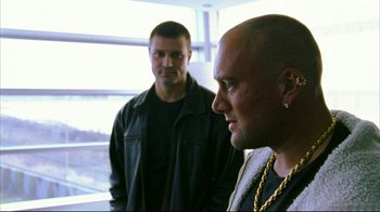 Movie still from “Pusher II” (2004), directed by Nicolas Winding Refn – Two men standing next to each other in front of a window; Close Up shot, Over the shoulder angle