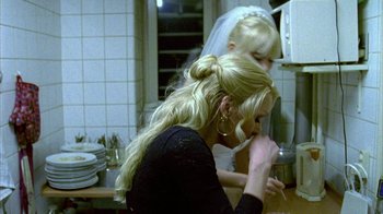 Movie still from “Pusher II” (2004), directed by Nicolas Winding Refn – A woman in a black shirt and a veil; Medium shot, Over the shoulder angle