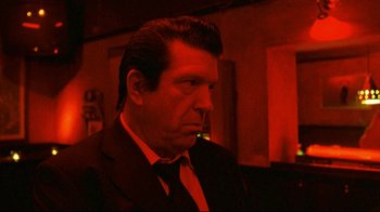 Movie still from “Pusher II” (2004), directed by Nicolas Winding Refn – A person wearing a suit and tie; Close Up shot, Low angle