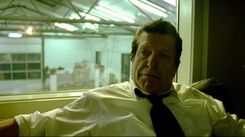 Movie still from “Pusher II” (2004), directed by Nicolas Winding Refn – A person wearing a shirt and a tie; Close Up shot, Low angle