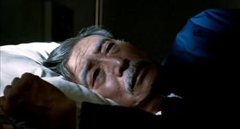 Movie still from “Pushing Hands” (1991), directed by Ang Lee – An older man is sleeping in a bed; Close Up shot, High angle