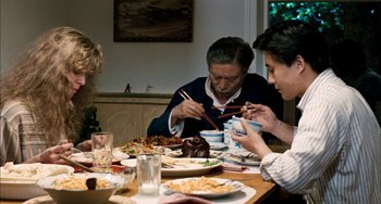 Movie still from “Pushing Hands” (1991), directed by Ang Lee – A group of people sitting at a table eating food; Medium shot, High angle