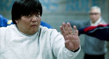 Movie still from “Pushing Hands” (1991), directed by Ang Lee – A man in a white shirt holding out his hand; Close Up shot, Low angle
