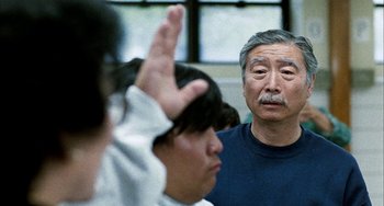 Movie still from “Pushing Hands” (1991), directed by Ang Lee – An older man is looking at a young man; Close Up shot, Over the shoulder angle