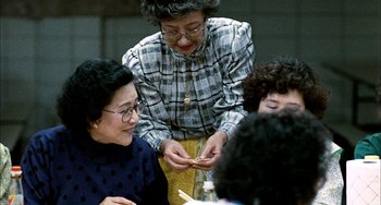 Movie still from “Pushing Hands” (1991), directed by Ang Lee – A group of people sitting around a table; Medium shot, High angle
