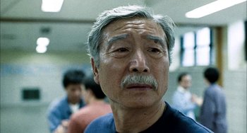 Movie still from “Pushing Hands” (1991), directed by Ang Lee – An older man with a mustache and a mustache comb; Close Up shot, Low angle