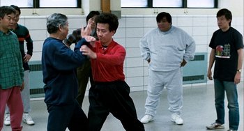 Movie still from “Pushing Hands” (1991), directed by Ang Lee – A group of people in a room playing a game; Wide shot, Over the shoulder angle