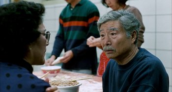 Movie still from “Pushing Hands” (1991), directed by Ang Lee – An older man sitting at a table with a bowl of noodles; Close Up shot, Over the shoulder angle