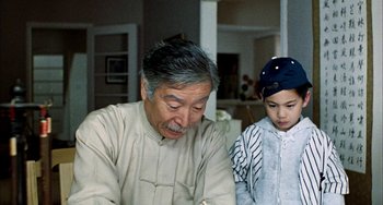 Movie still from “Pushing Hands” (1991), directed by Ang Lee – An older man and a young boy working on a project; Close Up shot, Over the shoulder angle