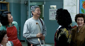 Movie still from “Pushing Hands” (1991), directed by Ang Lee – An older man is talking to an older woman; Medium shot, Over the shoulder angle