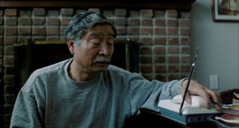 Movie still from “Pushing Hands” (1991), directed by Ang Lee – An older man sitting in front of a table; Close Up shot, High angle