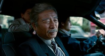 Movie still from “Pushing Hands” (1991), directed by Ang Lee – An older man sitting in the back seat of a car; Close Up shot, Low angle