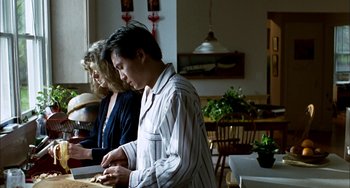 Movie still from “Pushing Hands” (1991), directed by Ang Lee – A man and a woman standing at a table in a room; Medium shot, Over the shoulder angle