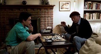 Movie still from “Pushing Hands” (1991), directed by Ang Lee – Two men sitting in front of a wooden board game; Medium shot, High angle