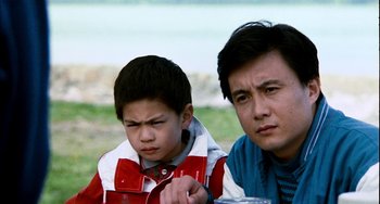 Movie still from “Pushing Hands” (1991), directed by Ang Lee – A man and a boy sitting next to each other on the grass; Close Up shot, Over the shoulder angle