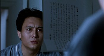 Movie still from “Pushing Hands” (1991), directed by Ang Lee – A man looking at a piece of paper with chinese writing on it in front of him; Close Up shot, Over the shoulder angle