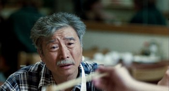 Movie still from “Pushing Hands” (1991), directed by Ang Lee – An older man is looking at the camera; Close Up shot, Over the shoulder angle
