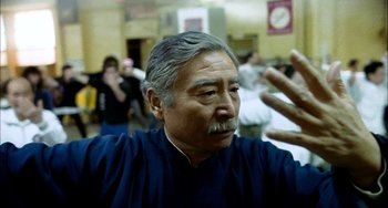 Movie still from “Pushing Hands” (1991), directed by Ang Lee – An older man with grey hair and a mustache; Close Up shot, Low angle
