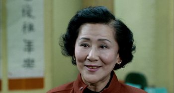 Movie still from “Pushing Hands” (1991), directed by Ang Lee – An older asian woman wearing a red jacket; Close Up shot, High angle