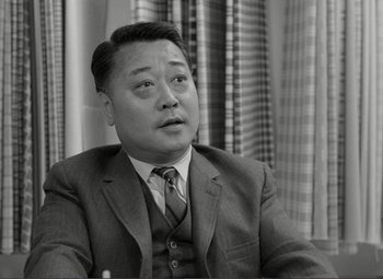 Movie still from “Putney Swope” (1969), directed by Robert Downey Sr. – An old black and white photo of a man wearing a suit; Close Up shot, Low angle