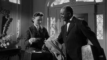 Movie still from “Queen Bee” (1955), directed by Ranald MacDougall – A man and a woman are looking at a suit jacket; Medium shot, Low angle