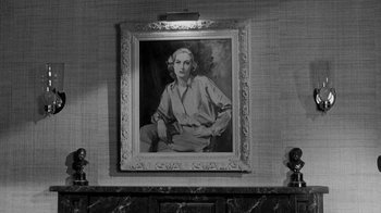 Movie still from “Queen Bee” (1955), directed by Ranald MacDougall – A black - and - white photo of a painting of a woman; Medium shot, Low angle