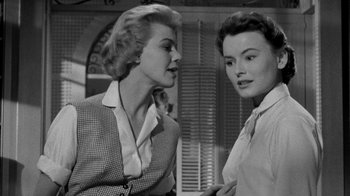 Movie still from “Queen Bee” (1955), directed by Ranald MacDougall – Two women talking to each other in front of a window; Medium shot, Low angle