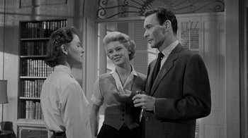 Movie still from “Queen Bee” (1955), directed by Ranald MacDougall – Two women and a man standing next to each other; Medium shot, Low angle